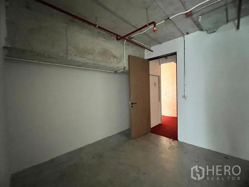 Retail Space for rent in Watthana, Bangkok - Back-of-house storage room with concrete floor and white walls.