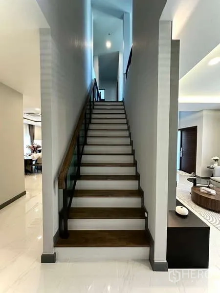 Detached House for rent in Bang Phli, Samut Prakan - Staircase with wood steps and glass balustrade leading to the upper floor.