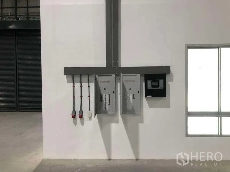 Factory for rent in Bang Sao Thong, Samut Prakan - Electrical control panels and conduit mounted on an interior wall.