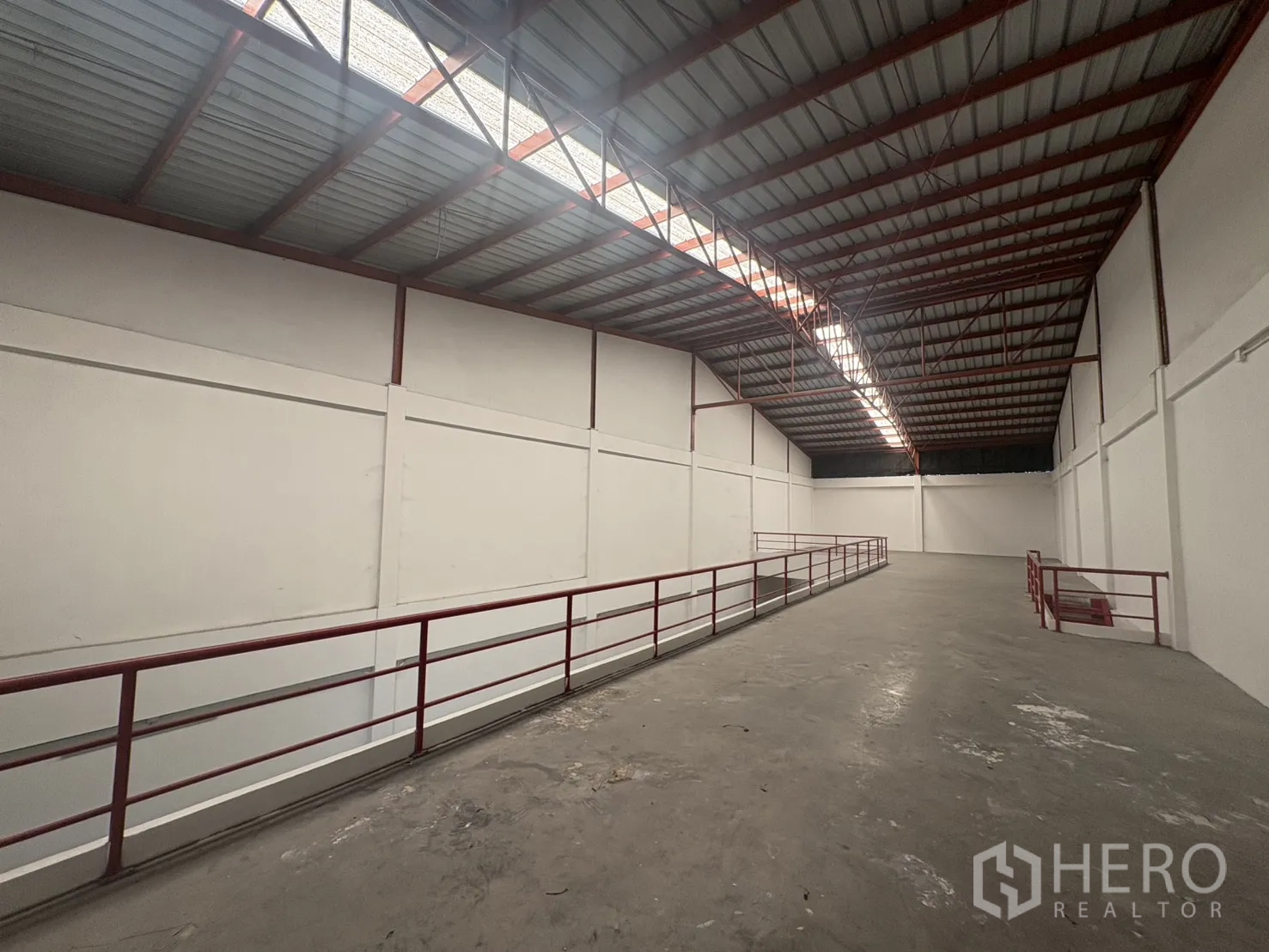 Factory for rent in Phra Samut Chedi, Samut Prakan - Mezzanine walkway with red railings under a high-span steel roof for extra storage.