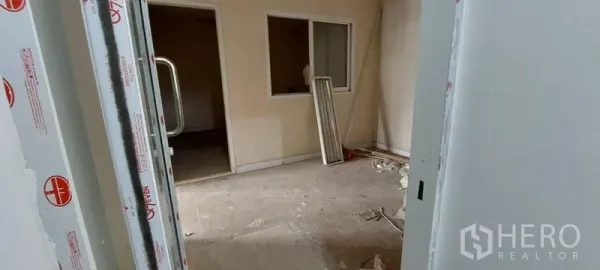 Retail Space for rent - Unfinished interior room with partition walls, windows, and renovation materials on the floor.