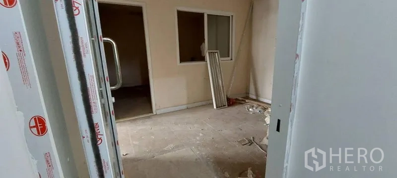 Retail Space for rent - Unfinished interior room with partition walls, windows, and renovation materials on the floor.
