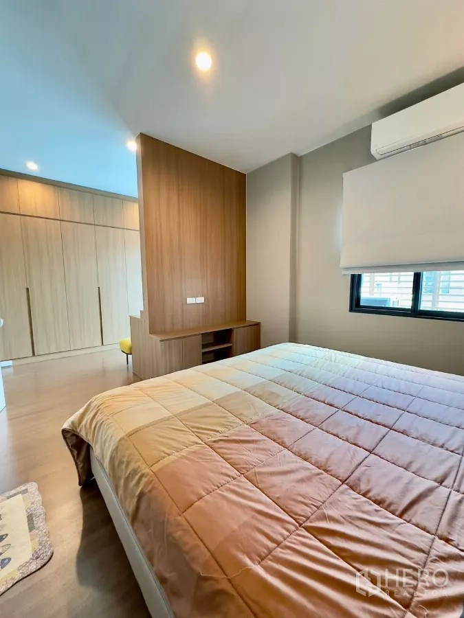 Detached House for rent in Samut Prakan - Master bedroom looking toward dressing area with divider and storage cabinetry.