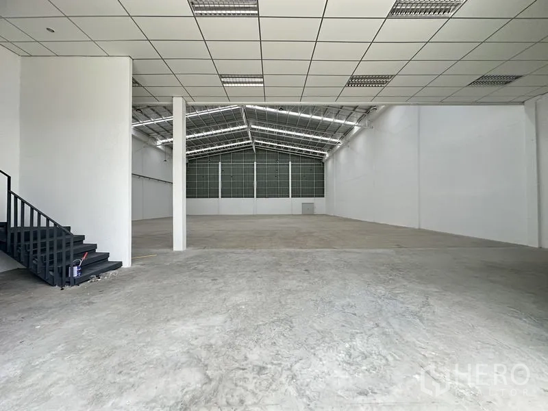 Factory for rent in Pathum Thani - Spacious production hall with 9-meter clear height, skylights, and reinforced concrete floor.