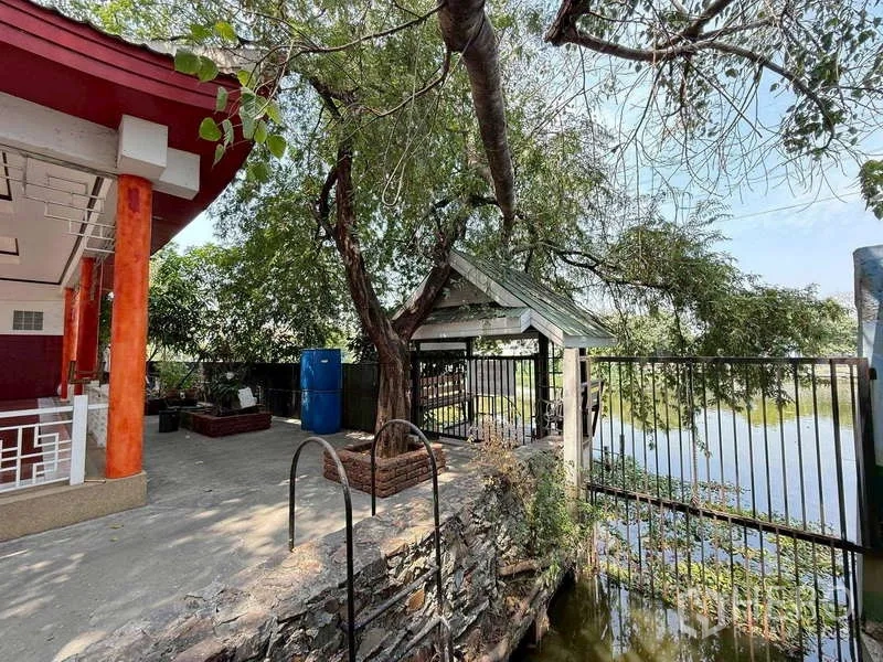 Warehouse for rent in Mueang Samut Prakan, Samut Prakan - Canal-side relaxation spot with trees, railing and a small pavilion.