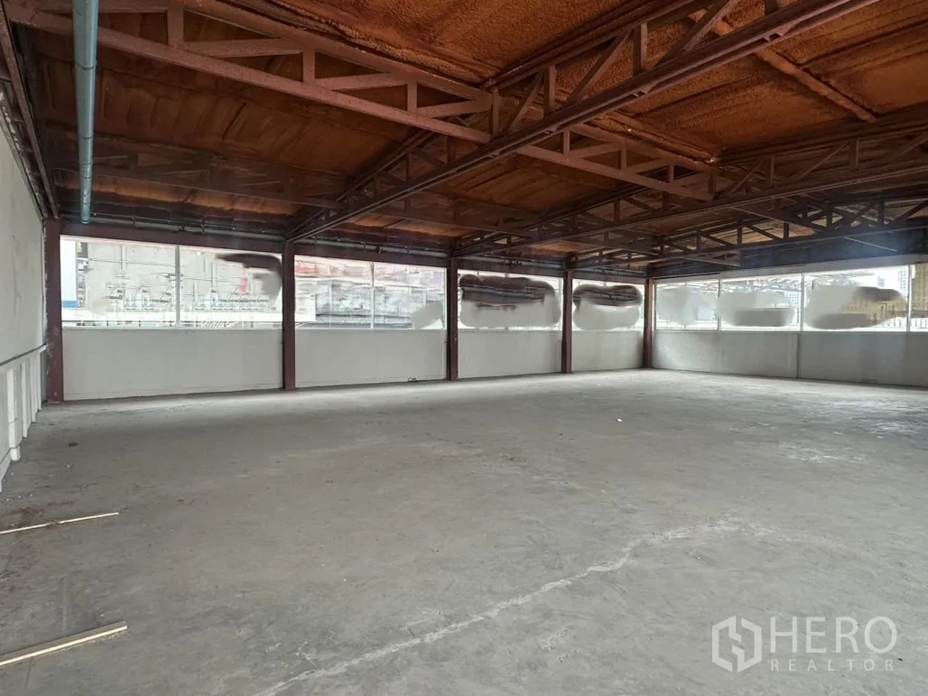Retail Space for rent in Watthana, Bangkok - Wide column-free showroom area featuring long ribbon windows and an industrial ceiling.