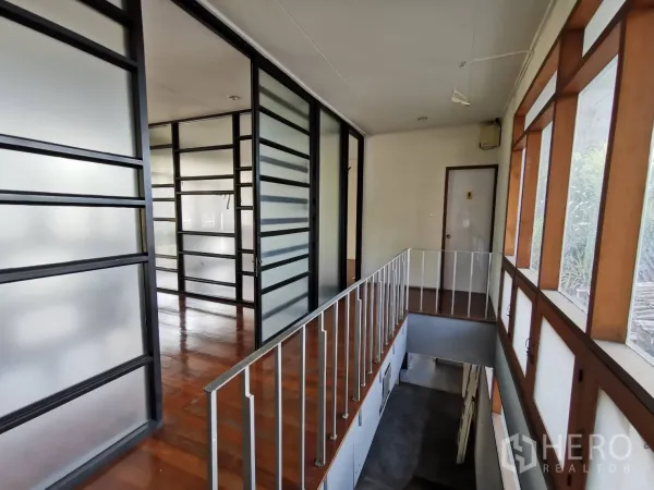 Home Office for rent in Watthana, Bangkok - Upper hallway with frosted-glass partitions and wood-framed windows.