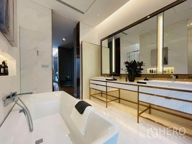 Condominium for sale in Pathum Wan, Bangkok - Spa-style bathroom with double vanity, oversized mirror and a freestanding bathtub in marble finishes.