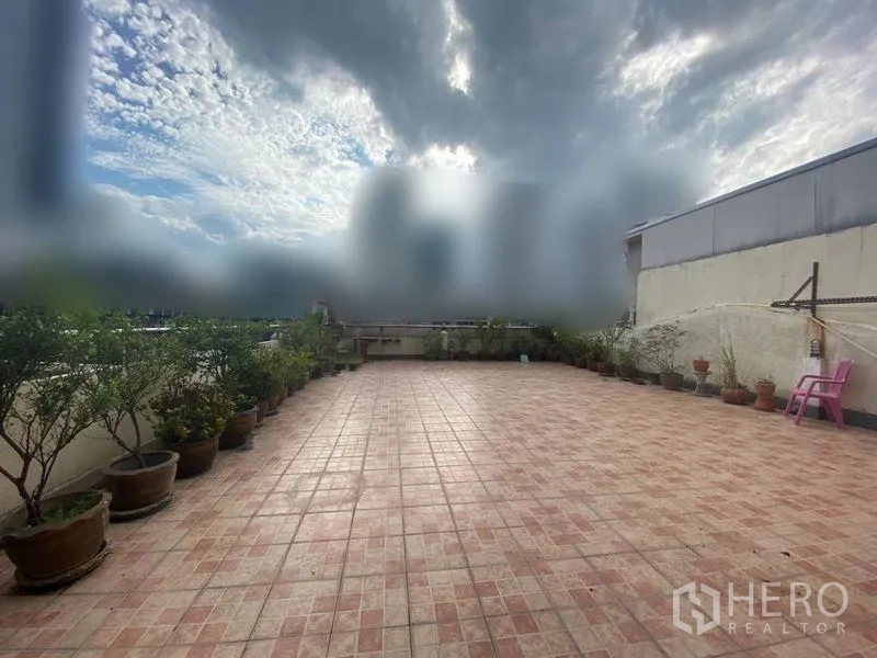 Retail Space for rent - Large tiled rooftop terrace with potted plants and open sky, ideal for outdoor retail display or events.