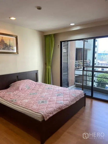 Condominium for rent in Pathum Wan, Bangkok - Second bedroom opening to a balcony through sliding glass doors with an urban outlook.