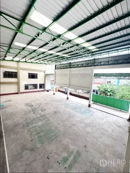 Warehouse for rent or sale in Thanyaburi, Pathum Thani - High-clearance warehouse floor viewed from mezzanine under skylight roof panels.