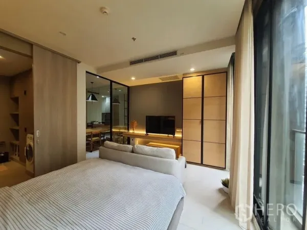 Condominium for rent in Pathum Wan, Bangkok - Bedroom featuring TV wall, large wardrobe and sliding glass to the dining room with abundant natural light.