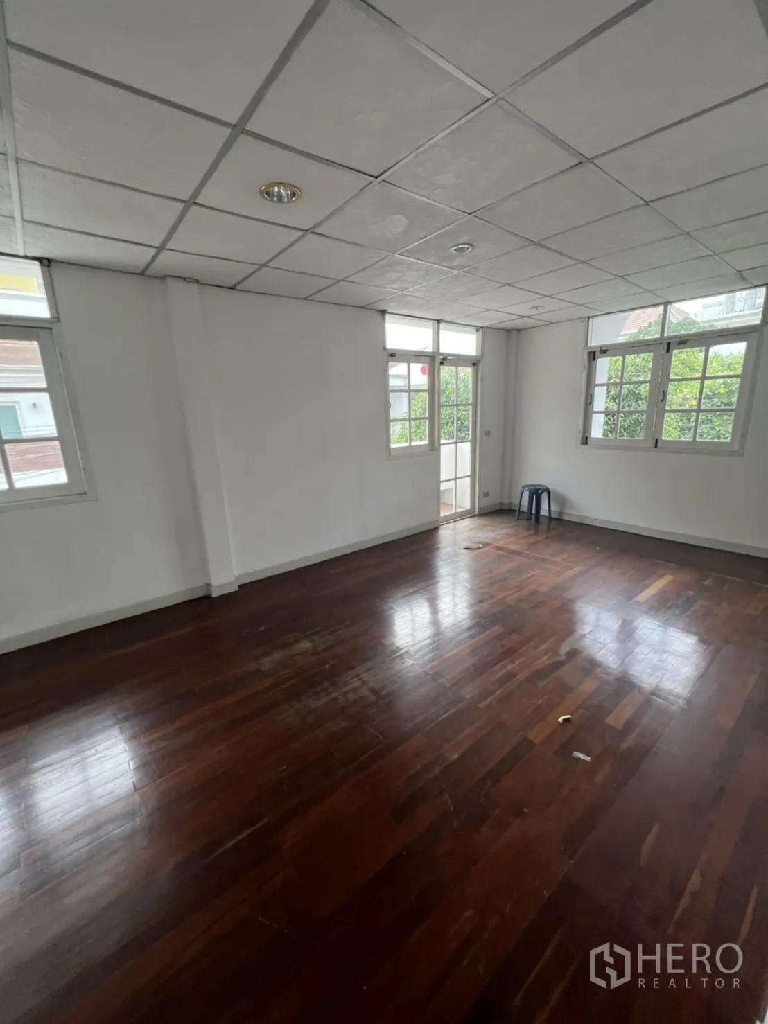 Detached House for rent or sale in Sathon, Bangkok - Corner bedroom with polished wood flooring and door to small balcony.