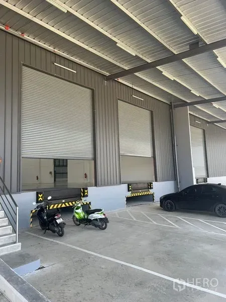 Factory for rent in Bang Pakong, Chachoengsao - Covered loading bays with dock levelers, roll-up doors, parking spaces and a ramp.