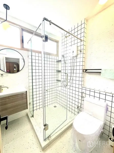 Townhouse for rent in Khlong Toei, Bangkok - Bathroom with glass shower, square grid wall tiles and toilet.