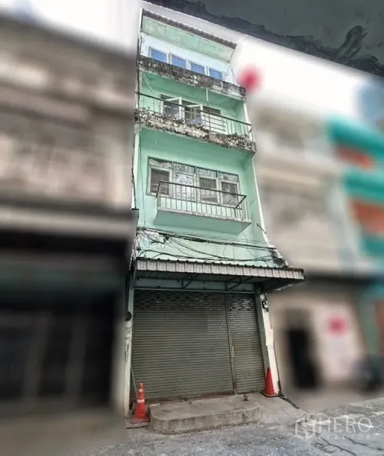 อาคารพาณิชย์ ให้เช่าในKhlong Toei, Bangkok - ด้านหน้าอาคารพาณิชย์ 4 ชั้น สีเขียวมิ้นท์ มีระเบียงและประตูม้วน บนซอยย่อย