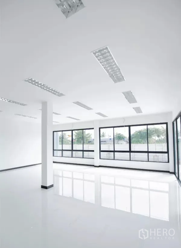 Factory for rent or sale in Nakhon Pathom - Ground-floor office space with full-height windows and linear LED lighting.