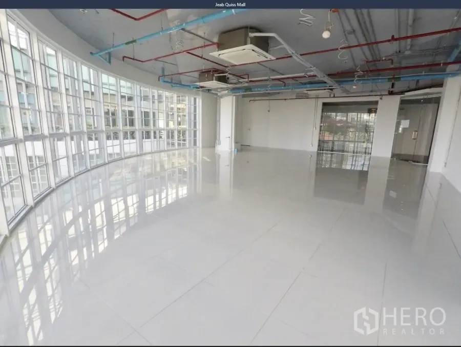Office Space for rent in Khlong Toei, Bangkok - Open-plan office with curved floor-to-ceiling windows, glossy tile floors, and exposed ceiling services.