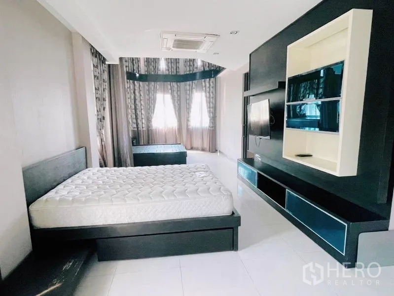 Detached House for rent or sale in Prawet, Bangkok - Spacious master bedroom with built-in media wall, bay windows and a large bed.