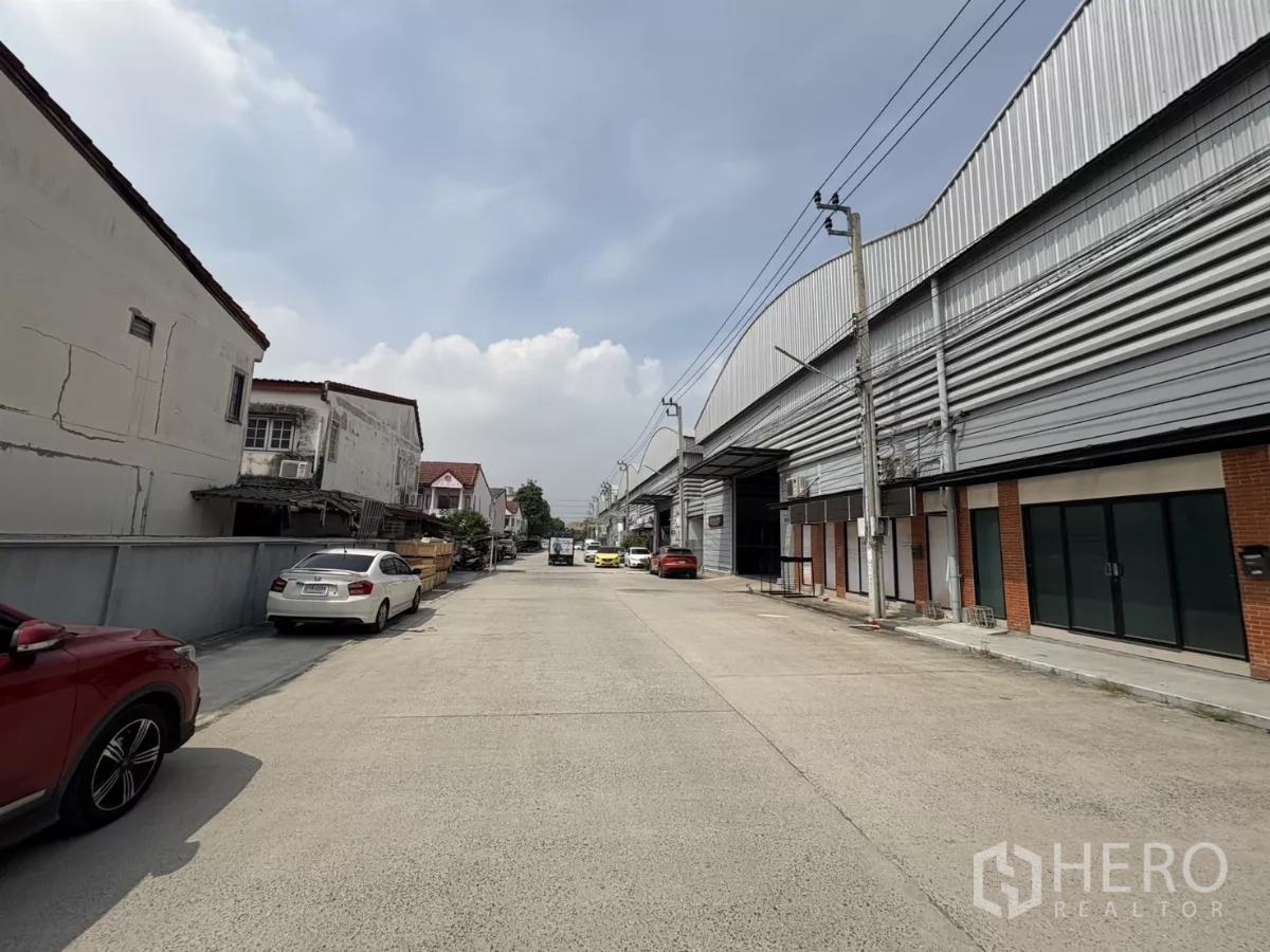 货栈 出租在Bang Phli, Samut Prakan - 宽阔的园区通道，整排仓库与路边停车位。