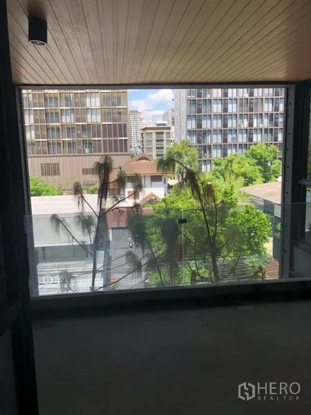 Retail Space for rent in Khlong Toei, Bangkok - Shaded terrace facing trees and mid-rise city buildings near Phrom Phong.