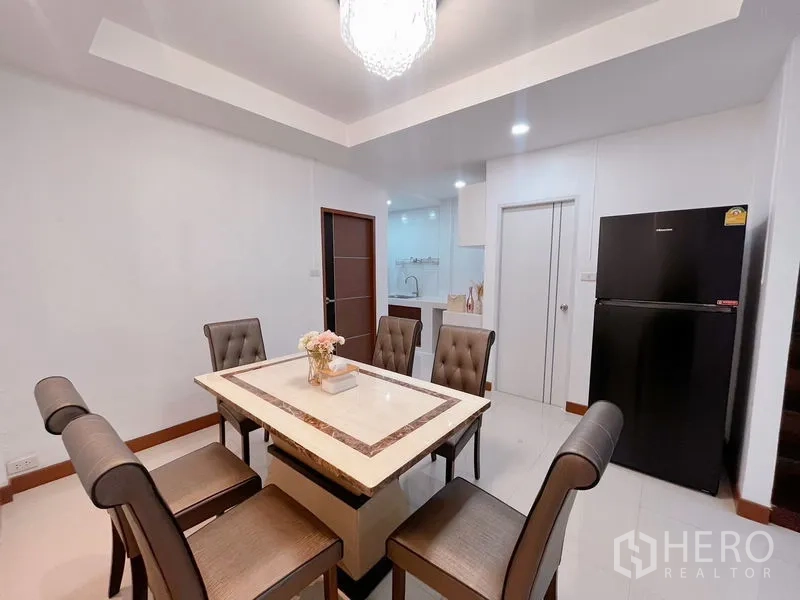 联排别墅 出租在Huai Khwang, Bangkok - 餐厅配大理石餐桌、软包座椅、冰箱与筒灯照明。