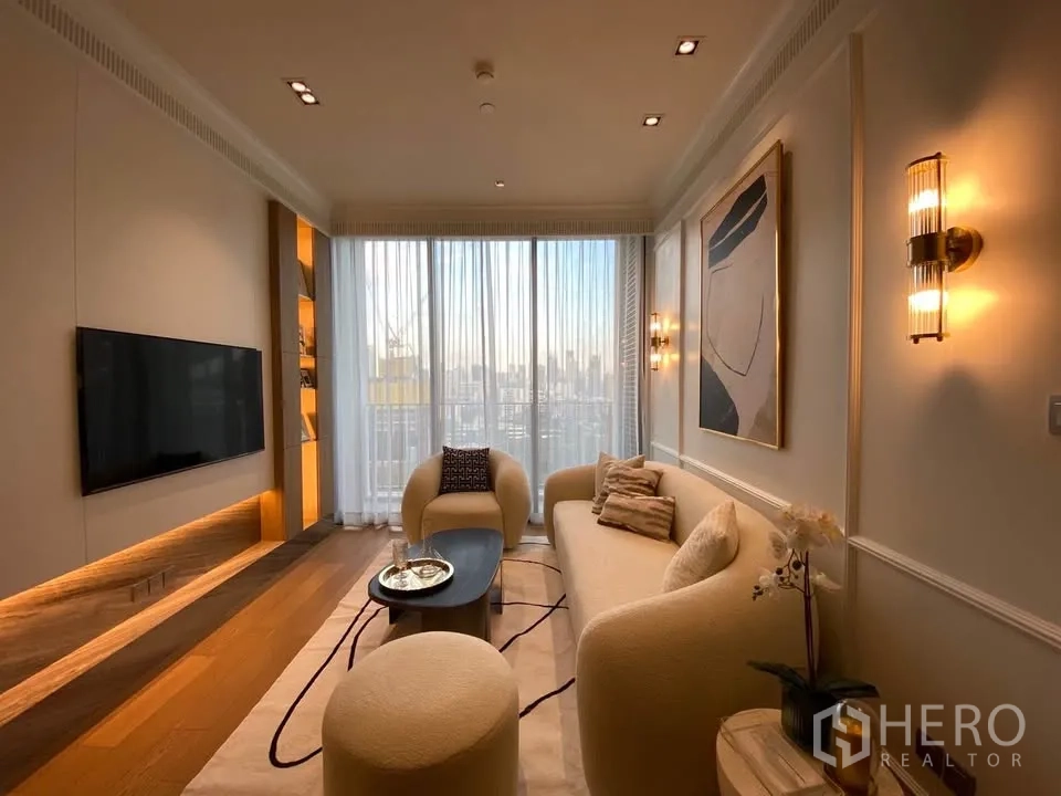 คอนโด for rent in Pathum Wan, Bangkok - มุมมองเต็มห้องนั่งเล่นพร้อมผนังทีวี แสงไฟซ่อน ม่านสูงเต็มผนัง และเฟอร์นิเจอร์สมัยใหม่