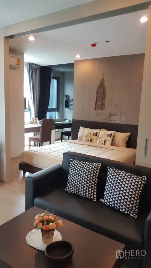 Condominium for rent in Bang Rak, Bangkok - Cozy 1-bedroom condo living area with sofa, bed, and a window-side work desk.