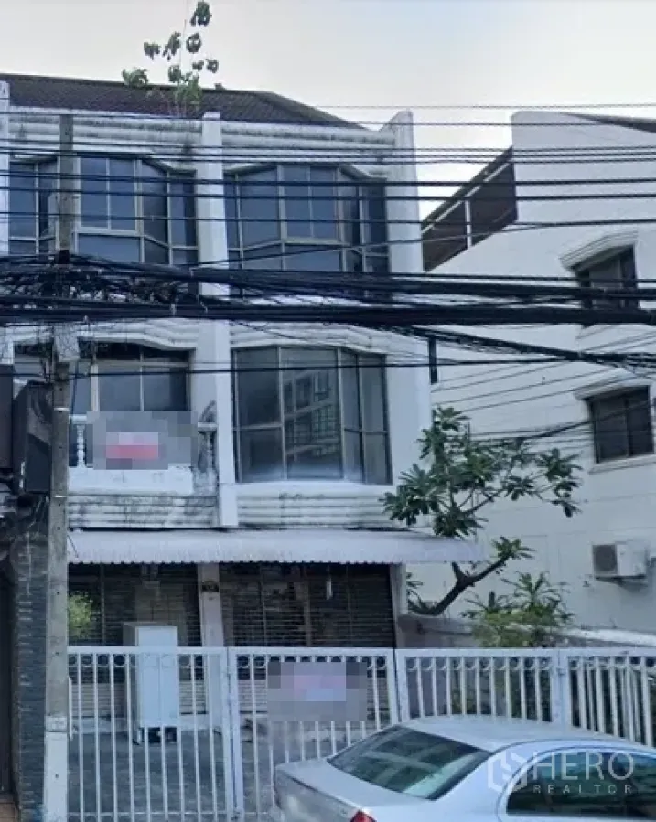 Retail Space for rent in Watthana, Bangkok - Street view of a three-storey shophouse with large bay windows and a gated frontage, power lines overhead.