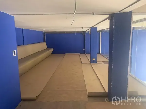 Shophouse for rent in Watthana, Bangkok - Mezzanine level with blue walls and protected flooring, ready for interior fit-out.