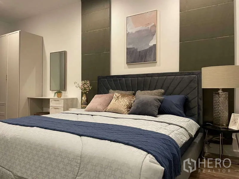 Detached House for rent in Bang Kapi, Bangkok - Second bedroom featuring a large bed, soft lighting and panel accent wall.
