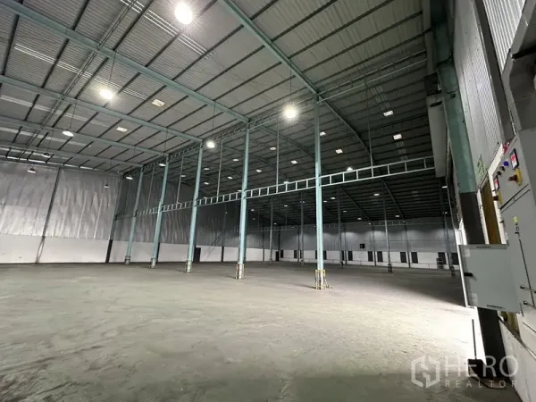 Warehouse for rent in Mueang Samut Prakan, Samut Prakan - Spacious warehouse interior with high steel columns, bright high-bay lights and smooth concrete floor.