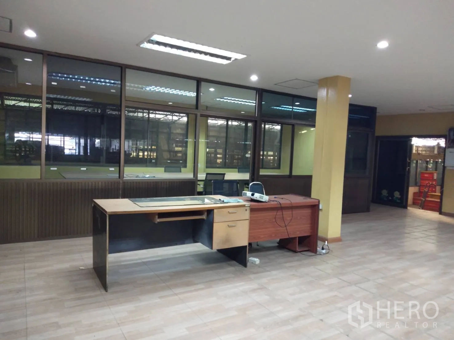Factory for rent in Lam Luk Ka, Pathum Thani - Open-plan office with desks, tiled flooring and large windows facing the factory.