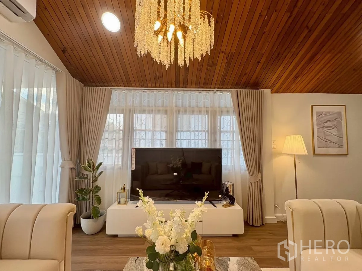 独立式住宅 出租在Huai Khwang, Bangkok - 电视墙区域，大窗与落地灯并搭配水晶吊灯