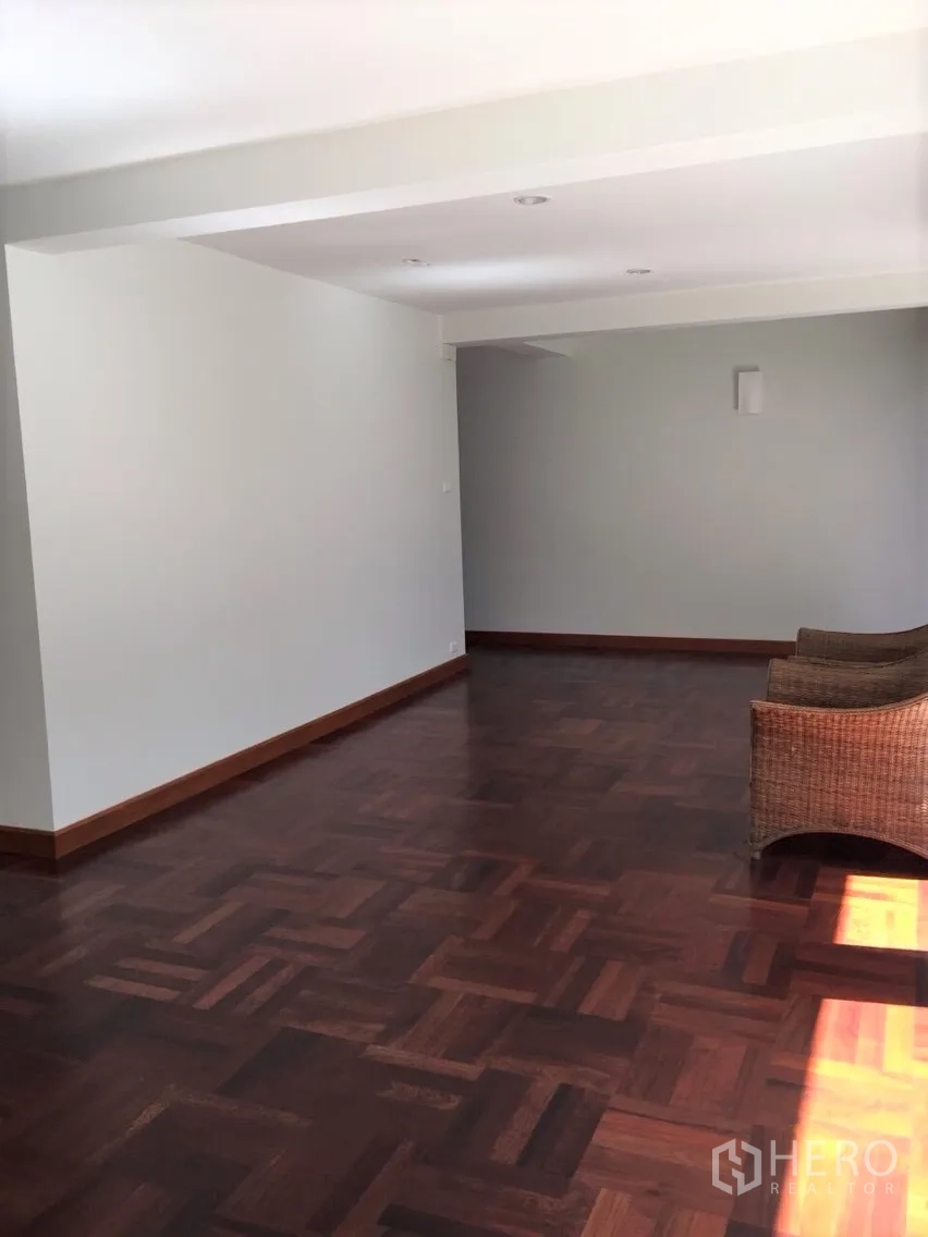 Detached House for rent in Sathon, Bangkok - Spacious living area with polished parquet wood floors and neutral walls.