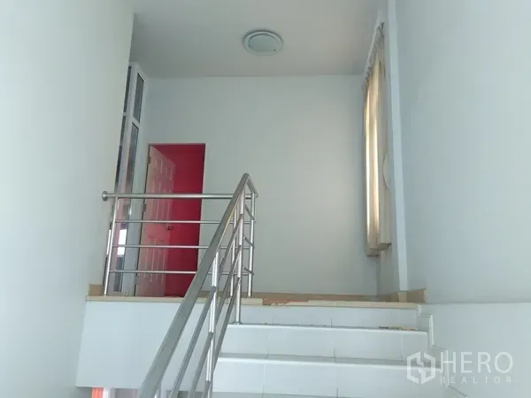 Factory for sale in Lam Luk Ka, Pathum Thani - Staircase with stainless-steel handrail connecting to the upper office area.
