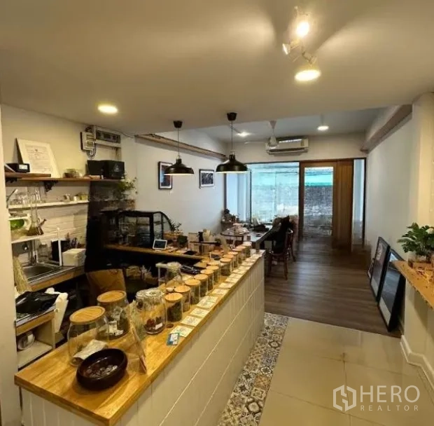 店屋 出租在Watthana, Bangkok - 开放式零售空间，服务吧台、置物架和临窗休息区。