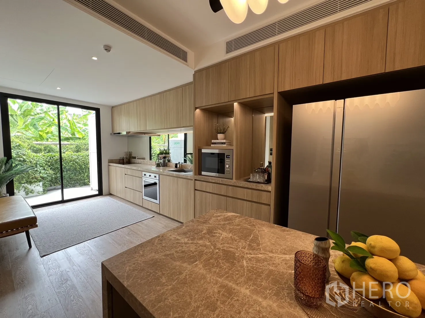 Townhouse for sale in Watthana, Bangkok - Bright galley kitchen with long counter, bench seating and patio access.