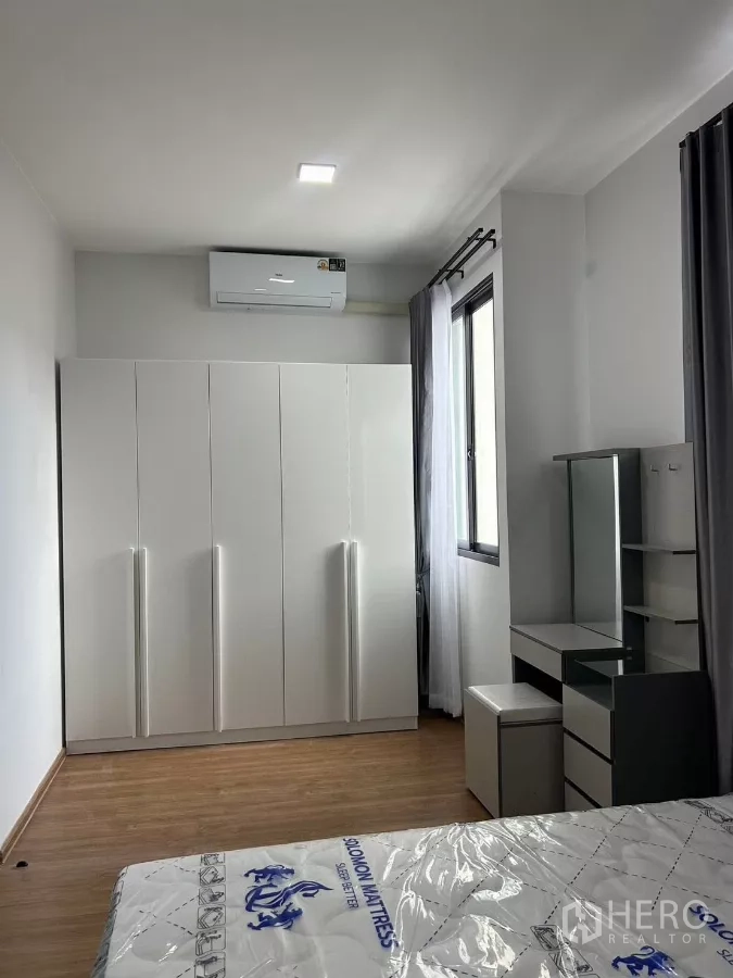 Townhouse for rent in Bang Phli, Samut Prakan - Master bedroom corner showing wardrobe and dressing table near the window.