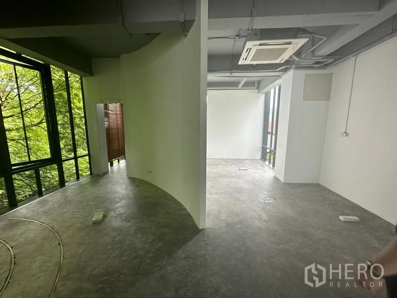 Office Space for rent in Khlong Toei, Bangkok - Open-plan zone with curved partition wall, cassette air-conditioner and large windows.