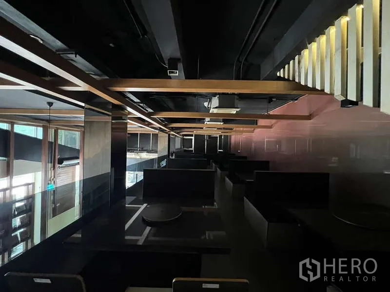 Shophouse for rent or sale in Khlong Toei, Bangkok - Upper dining area with booth seating and exposed ceiling beams.
