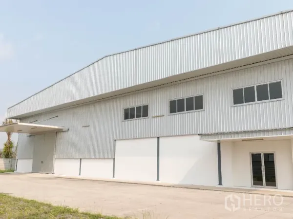 โรงงาน ให้เช่าในSi Racha, Chon Buri - ด้านหน้าคลังสินค้าพร้อมประตูม้วนและกันสาดทางโหลด
