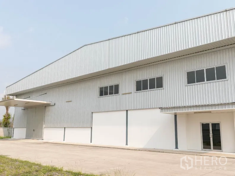 โรงงาน ให้เช่าในSi Racha, Chon Buri - ด้านหน้าคลังสินค้าพร้อมประตูม้วนและกันสาดทางโหลด
