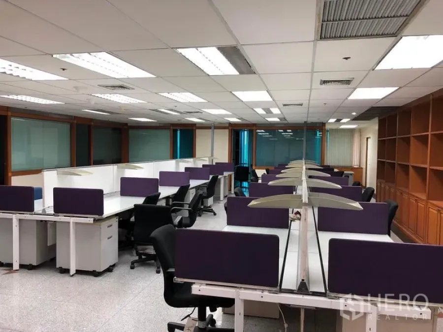 Office Space for rent in Din Daeng, Bangkok - Large workstation zone with long desks, purple screens and wall shelving.