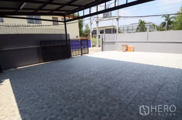 Home Office for rent in Lat Phrao, Bangkok - Shaded carport looking toward the street with double gate and privacy wall.