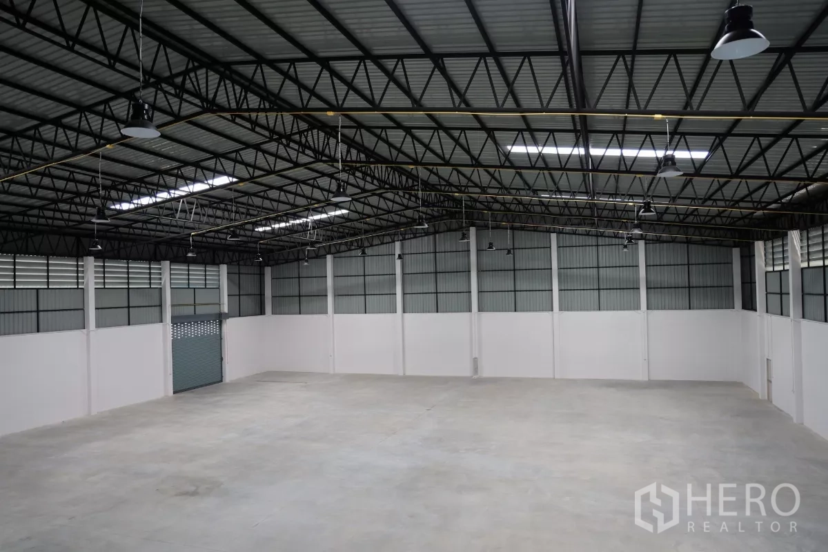 Factory for rent or sale in Bang Len, Nakhon Pathom - Wide angle of the column-free factory floor and high roof with ventilation panels and roller door.
