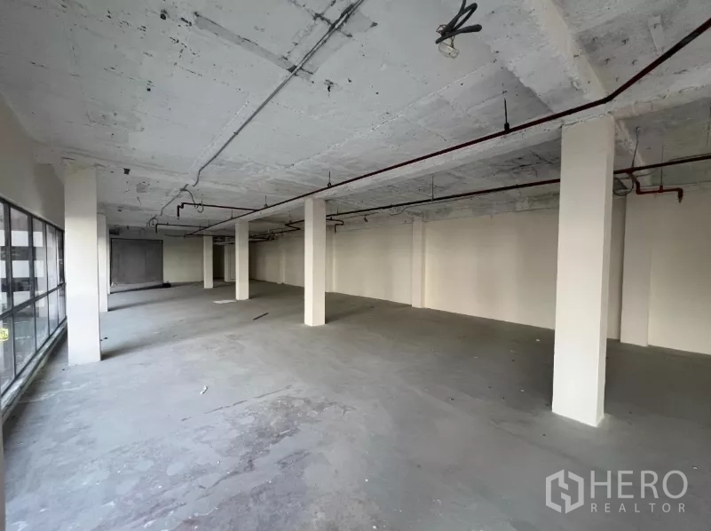 Retail Space for rent in Watthana, Bangkok - Unfurnished retail hall with bare concrete floor and structural pillars.