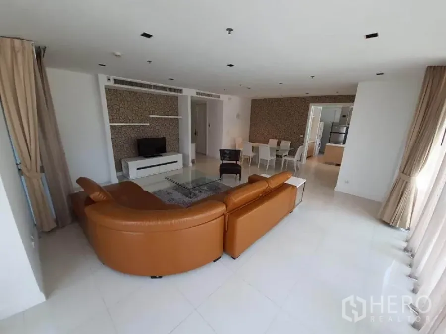 Condominium for rent in Pathum Wan, Bangkok - Bright open-plan living and dining area with leather sectional sofa, TV console, and large windows in a Bangkok condo.