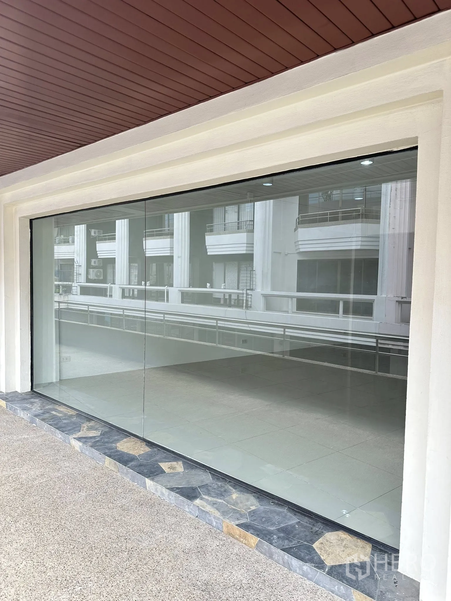 Office Space for rent in Watthana, Bangkok - Exterior view of wide glass shopfront with stone-trimmed threshold.
