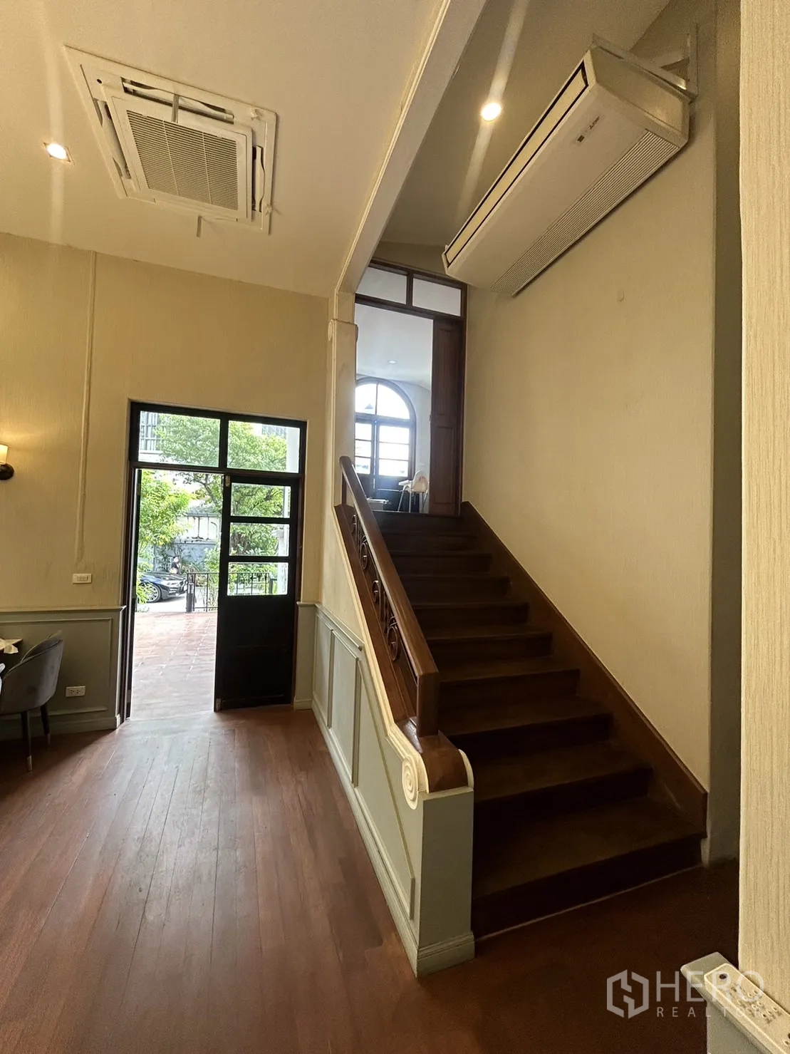 Retail Space for rent in Bangkok - Entrance hall with high ceiling and wooden staircase leading to the upper level of the retail space.